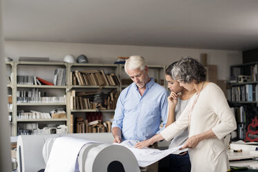 Multiethnische Innenarchitekten analysieren Baupläne im Büro - CAVF33611