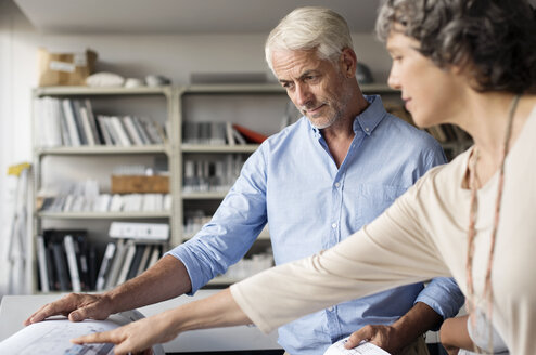 Innenarchitekten diskutieren in ihrem Büro über einen Bauplan - CAVF33612