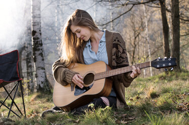 Schöne Frau spielt Gitarre im Wald - CAVF33683