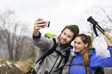 Hikers taking selfie on mountain during winter - CAVF33691