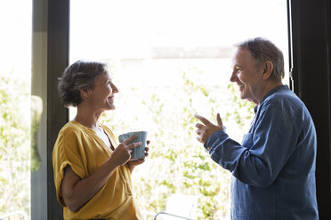 Seitenansicht eines älteren Paares, das zu Hause am Fenster Kaffee trinkt - CAVF33766