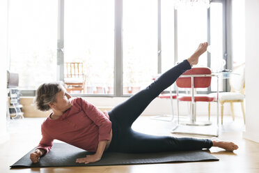 Determined mature woman exercising on floor at home - CAVF33790