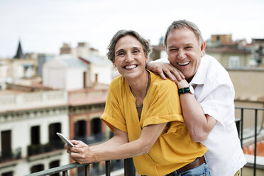 Portrait of happy senior couple standing on terrace - CAVF33810