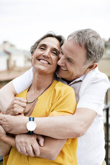 Liebender älterer Mann umarmt Frau auf Terrasse - CAVF33811