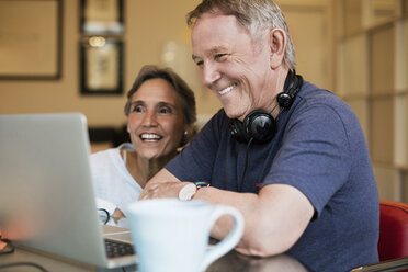 Glückliches älteres Ehepaar benutzt Laptop zu Hause - CAVF33832