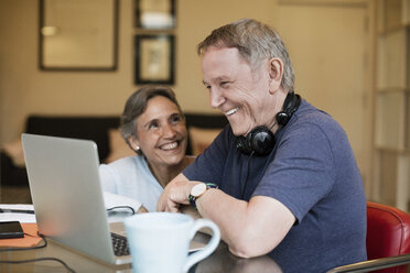 Fröhliches älteres Ehepaar benutzt Laptop zu Hause - CAVF33833