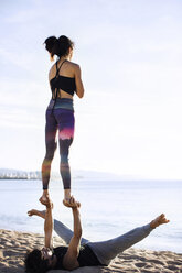 Pärchen beim Yoga am Ufer gegen den Himmel - CAVF33866