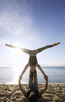 Entschlossenes multiethnisches Paar macht Yoga am Ufer gegen den Himmel - CAVF33868