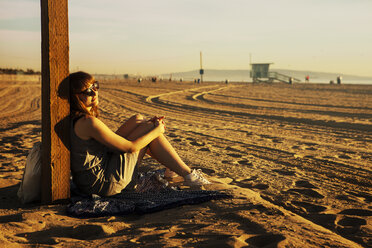 Mid adult Frau sitzend am Strand - FOLF07888