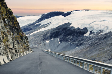View down road leading along snowy mountain at Norway - FOLF07920