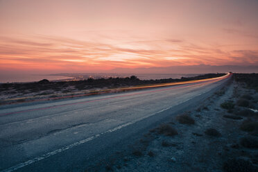 Blick auf die Lichtspur auf der Straße am Meer bei Sonnenuntergang - FOLF07932