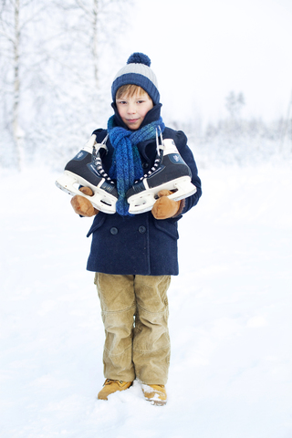 Porträt eines kleinen Jungen mit Schlittschuhen, lizenzfreies Stockfoto