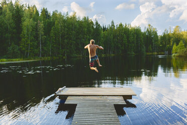 Young man jumping off pier into lake - FOLF08077