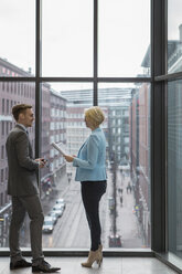 Geschäftsleute diskutieren am Fenster über ein Projekt - FOLF08165