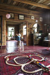 Boy playing with balloon in living room - FOLF08172