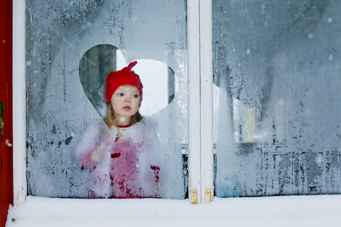 Mädchen schaut durch ein Milchglasfenster, lizenzfreies Stockfoto