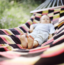 Baby girl lying on hammock, focus on bare feet - FOLF08357