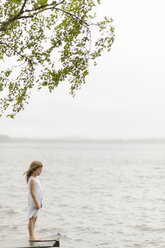 Girl standing on jetty by lake - FOLF08454