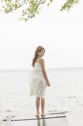 Girl standing on jetty by lake - FOLF08457