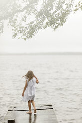 Girl standing on jetty by lake - FOLF08461