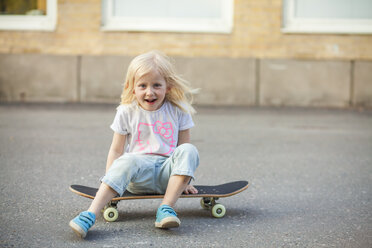 Girl sitting on skateboard - FOLF08559