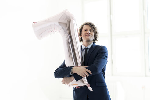 Proud businessman holding a No 1 balloon - HHLMF00163