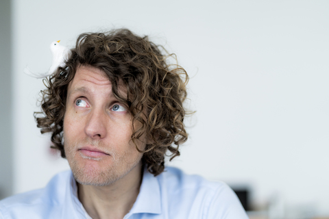 Geschäftsmann spielt mit einem Spielzeugvogel, lizenzfreies Stockfoto