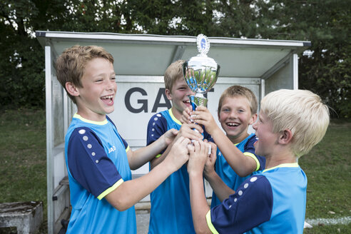 Young football players cheering with cup - WESTF24032