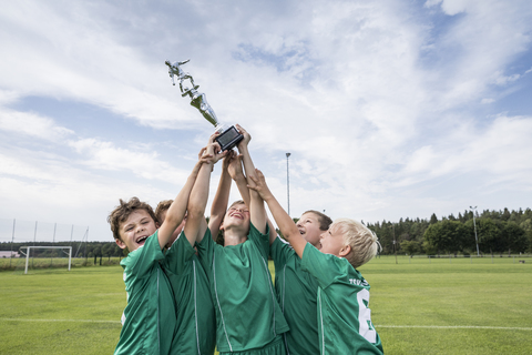 Young football players cheering with cup stock photo