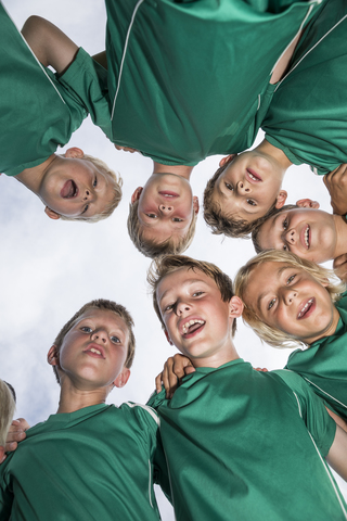 Happy young football players huddling stock photo