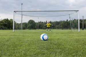 Junger Fußballtorwart mit Ball auf Fußballplatz - WESTF24039