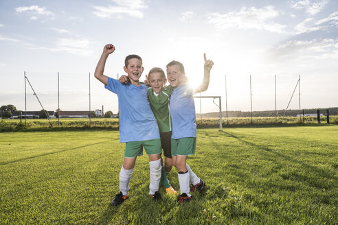 Young football players cheering on football ground - WESTF24043