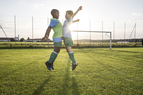 Young football players jumping on football ground - WESTF24048