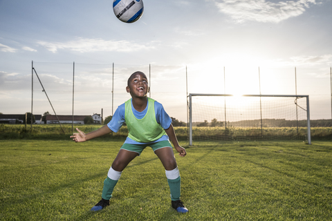 Junger Fußballspieler köpft den Ball auf dem Fußballplatz, lizenzfreies Stockfoto