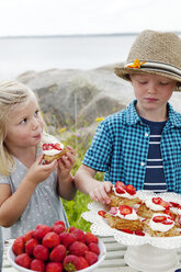Children eating strawberry dessert outdoors - FOLF08664