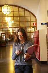 Studentin, die eine SMS auf ihrem Mobiltelefon schreibt - FOLF08722