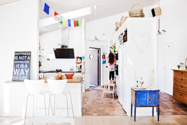 Home interior with woman reaching into cabinet - FOLF08746