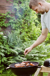 Man grilling sausages - FOLF08760