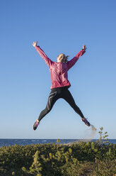 Young woman jumping with sea on background - FOLF08866