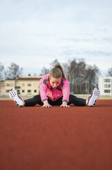 Young woman stretching on court - FOLF08868