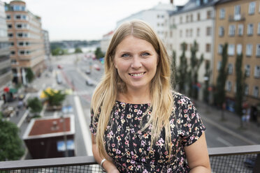 Portrait of woman standing on balcony - FOLF08965