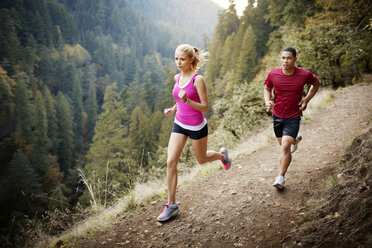 Männlicher und weiblicher Athlet beim Laufen am Berg - CAVF33952