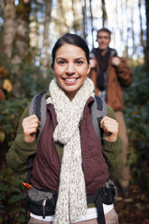 Porträt einer glücklichen Frau beim Wandern mit einem Mann im Wald - CAVF33964
