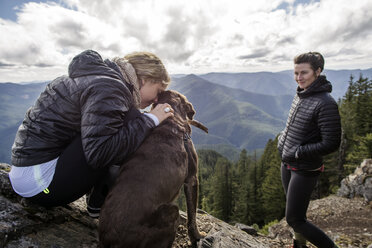 Frauen mit Hund beim Wandern an einer Bergklippe - CAVF33999