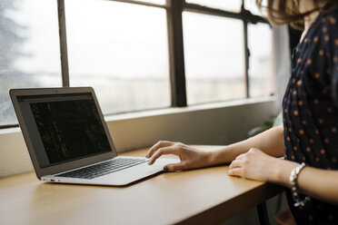 Frau benutzt Laptop auf Tisch in Café - CAVF34028