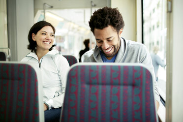 Glückliches multiethnisches Paar auf Reisen im Bus - CAVF34045