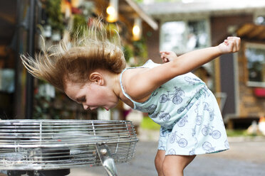 Mädchen schreit, während sie die Brise eines elektrischen Ventilators genießt - CAVF34174