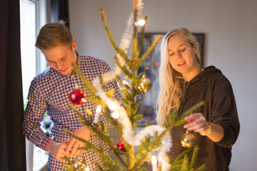 Ehepaar schmückt Weihnachtsbaum - FOLF09086