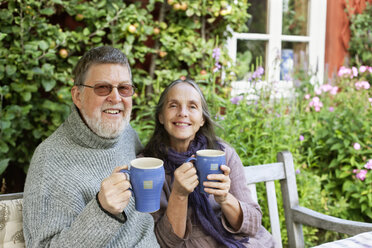 Senior couple drinking coffee in garden - FOLF09093