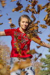 Teenager-Mädchen springt mit Herbstblättern - FOLF09109